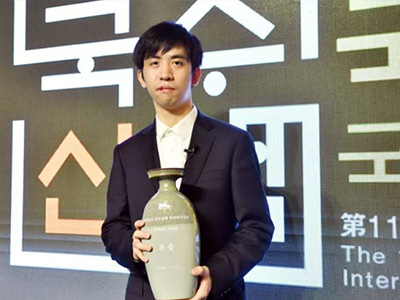 図2：王星昊九段が第11回国手山脈杯の優勝トロフィーを受け取る様子。