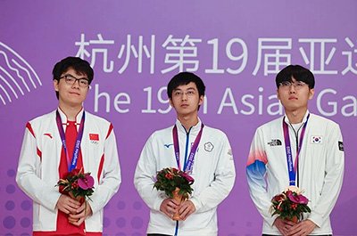 図4：男子個人戦の優勝、準優勝、3位が並ぶ。左から銀メダルの柯九段、金メダルの許九段、銅メダルの申九段。