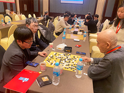 図3：聶衛平九段とその息子・孔令文七段（43歳）が、武宮正樹九段と共に対局を検討。