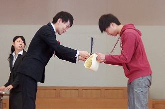 学生最強位戦優勝の大関さん、坂井八段から賞状と楯を受け取る