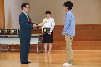最強位戦優勝の山田さん、坂井八段から賞状と楯を受け取る